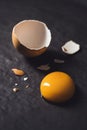 Broken egg with egg yolk on black textured background Royalty Free Stock Photo