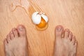 broken egg and feet on the floor in kitchen