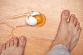 broken egg and feet on the floor in kitchen