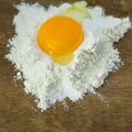 Broken egg on flour, means for making bread. Royalty Free Stock Photo