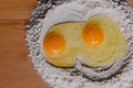 Broken egg on flour, means for making bread. Close-up raw egg yolk on flour with selective focus Royalty Free Stock Photo