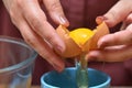A broken egg in the hands, the separation of the yolk and protein for baking