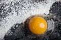 Broken egg on layer of flour on the black background Royalty Free Stock Photo