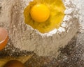 Broken egg on top of a bunch of white rye flour. Preparation of dough or bread.