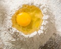 Broken egg on top of a bunch of white rye flour. Preparation of dough or bread. Royalty Free Stock Photo