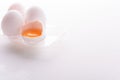 Broken egg with whole eggs in a transparent plastic container on white wooden background Royalty Free Stock Photo