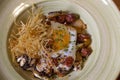 Broken eggs with black pudding and Iberian sausage on a ceramic plate. Isolated image. Creative cuisine