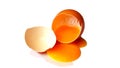 Broken eggs, yolks flowing out on white background