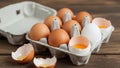 Broken eggshells rest beside it with visible yolks and whites Royalty Free Stock Photo