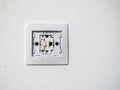 Broken electrical switch on the wall. Switch without button. Disassembled device. White wall with electric light switch.