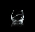 Broken empty whiskey glass isolated on black background Royalty Free Stock Photo