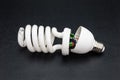 Broken energy saving light bulb, isolated on a black background with a clipping path. Royalty Free Stock Photo