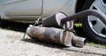 Broken exhaust and muffler of a car, rusted silencer fallen down on the road, breakdown of vehicle Royalty Free Stock Photo