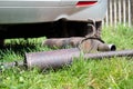 Broken exhaust and muffler of a car, rusted silencer fallen down on the road, breakdown of vehicle Royalty Free Stock Photo