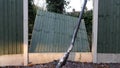 Broken fence panel with bent lamp post in the foreground