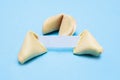 Broken fortune cookies on a blue background and place for text. Mockup. Blank paper for writing a fortune. Royalty Free Stock Photo