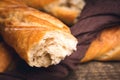 Broken fresh baguette, close up. Fresh baked bread loaf on wooden background. Tasty broken bread Royalty Free Stock Photo