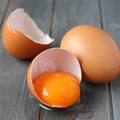 Broken fresh egg on rustic wooden background