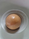 Broken fresh egg in small white bowl in refrigerator in kitchen