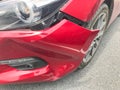 Broken front bumper of red car