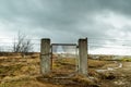 Broken gate on a field with barb wire Royalty Free Stock Photo