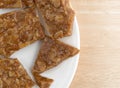 Broken ginger brittle on a plate atop wood table Royalty Free Stock Photo