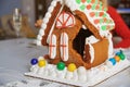 Broken Gingerbread house on the table in Christmas decorated room