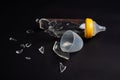 Broken glass baby bottle on dark Royalty Free Stock Photo