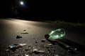 broken glass bottle on a quiet, dark road