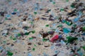 Broken glass bottles on white sand. Bottles is green and blue colour. Trash on the sand. Ecological problem Royalty Free Stock Photo