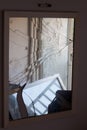 Broken glass with cracks and reflection of abandoned room. The mirror shattered into fragments. Cracks on white glass. The symbol