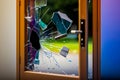 Broken glass door is shown in front of blue wall. Generative AI Royalty Free Stock Photo