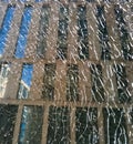 Through the broken glass, the facade of the building with blue windows is reflected. Office modern building. Royalty Free Stock Photo
