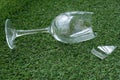 Broken glass goblet on artificial turf.