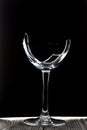 Broken glass goblet. Stands on black boards. Shot on a black background Royalty Free Stock Photo