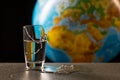 Broken glass and its fragments with leaking water on the background of the globe, map of the African continent Royalty Free Stock Photo