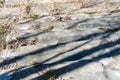 Broken glass on an old concrete staircase. The shadow falls on the remnants of former luxury. The concept of poverty and hunger in