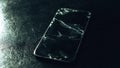 Broken glass screen smartphone on a black textured background with green light. Cracked glass on a screen. Crash phone, fractured Royalty Free Stock Photo