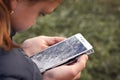Broken glass screen smartphone in hand of sad girl. Cracked phone display Royalty Free Stock Photo