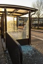 Broken glass wall at a bus stop..