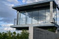 Broken glass in the windows of a large modern house against the blue sky