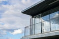 Broken glass in the windows of a large modern house against the blue sky