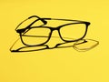 Broken glasses, eyeglasses, lens fallen out on yellow background for copyspace. Optical health or eyewear. Royalty Free Stock Photo