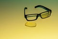 Broken glasses with folded arches lie on a yellow surface Royalty Free Stock Photo