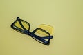 Broken glasses with folded arches lie on a yellow surface. Nearby is a yellow lens that has fallen out of the frame. View from Royalty Free Stock Photo
