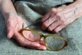 Broken glasses in the hands of an old woman. Royalty Free Stock Photo