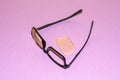 Broken glasses lie on a purple surface. Nearby lies a yellow lens that has fallen out of the frame. View from above Royalty Free Stock Photo