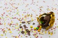 Broken golden chocolate easter eggs with colorful chocolates inside on white background with colorful blurred confetti Royalty Free Stock Photo