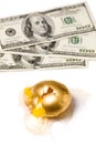 Broken golden egg and dollars