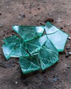 Broken green glass shards on rough surface. Royalty Free Stock Photo